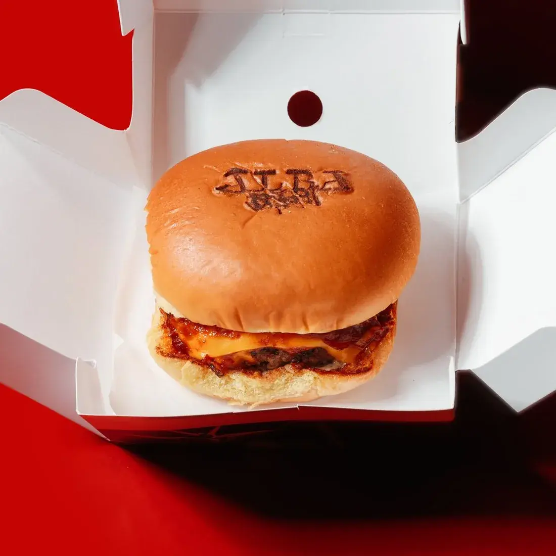 A5 Wagyu Kimchi Burger in an open Alba Street takeaway box against a red backdrop at Alba Street, Social Distrikt, Dubai Mall