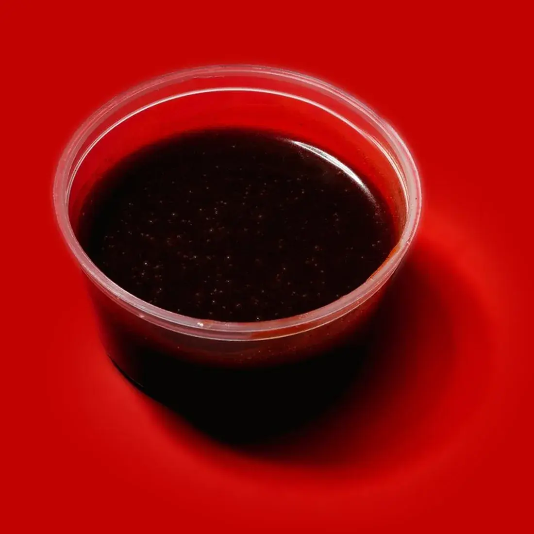 Black Pepper Sweet Soy Sauce in a dip pot against a red backdrop at Alba Street, Social Distrikt, Dubai Mall