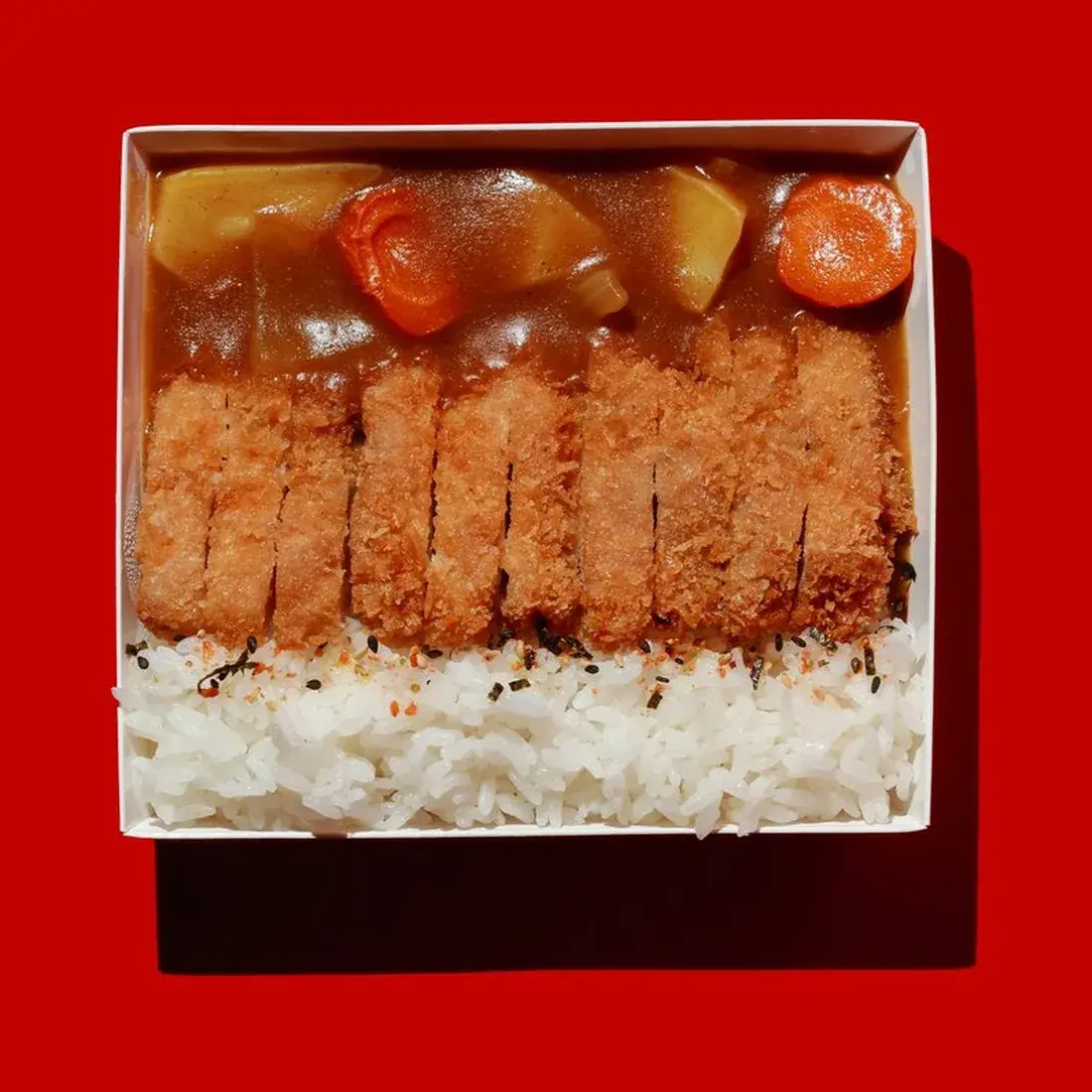 Chicken Katsu Curry Rice Bowl in an Alba Street presentation box against a red backdrop at Alba Street, Social Distrikt, Dubai Mall