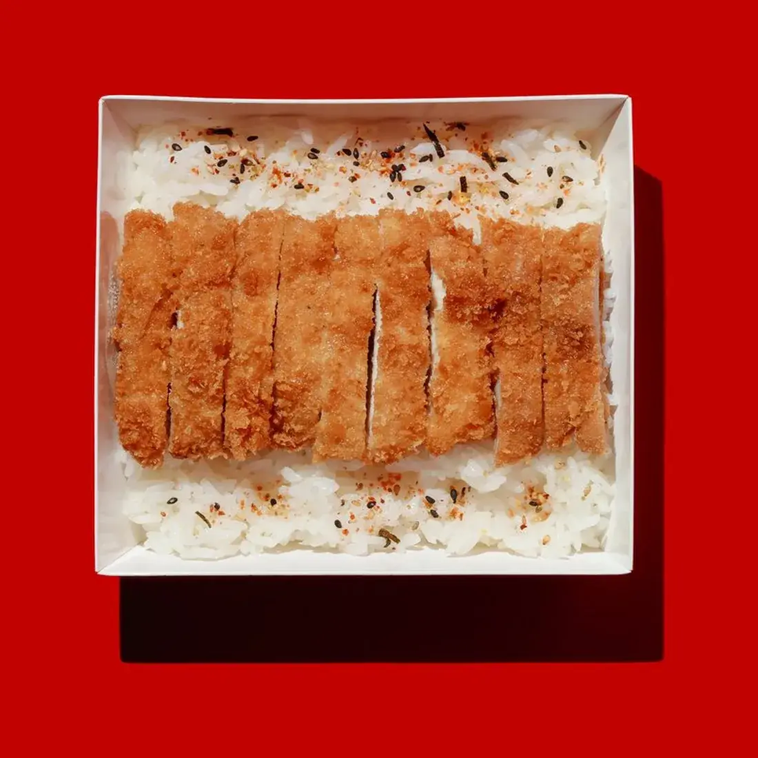 Chicken Katsu Rice Bowl in a bowl against a red backdrop at Alba Street, Social Distrikt, Dubai Mall
