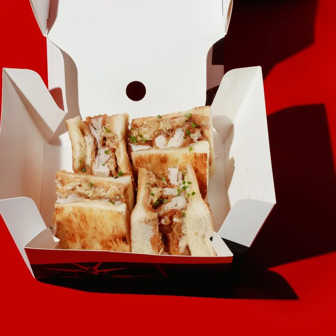 Chicken Truffle Sando in an open Alba Street takeaway box against a red backdrop at Alba Street, Social Distrikt, Dubai Mall