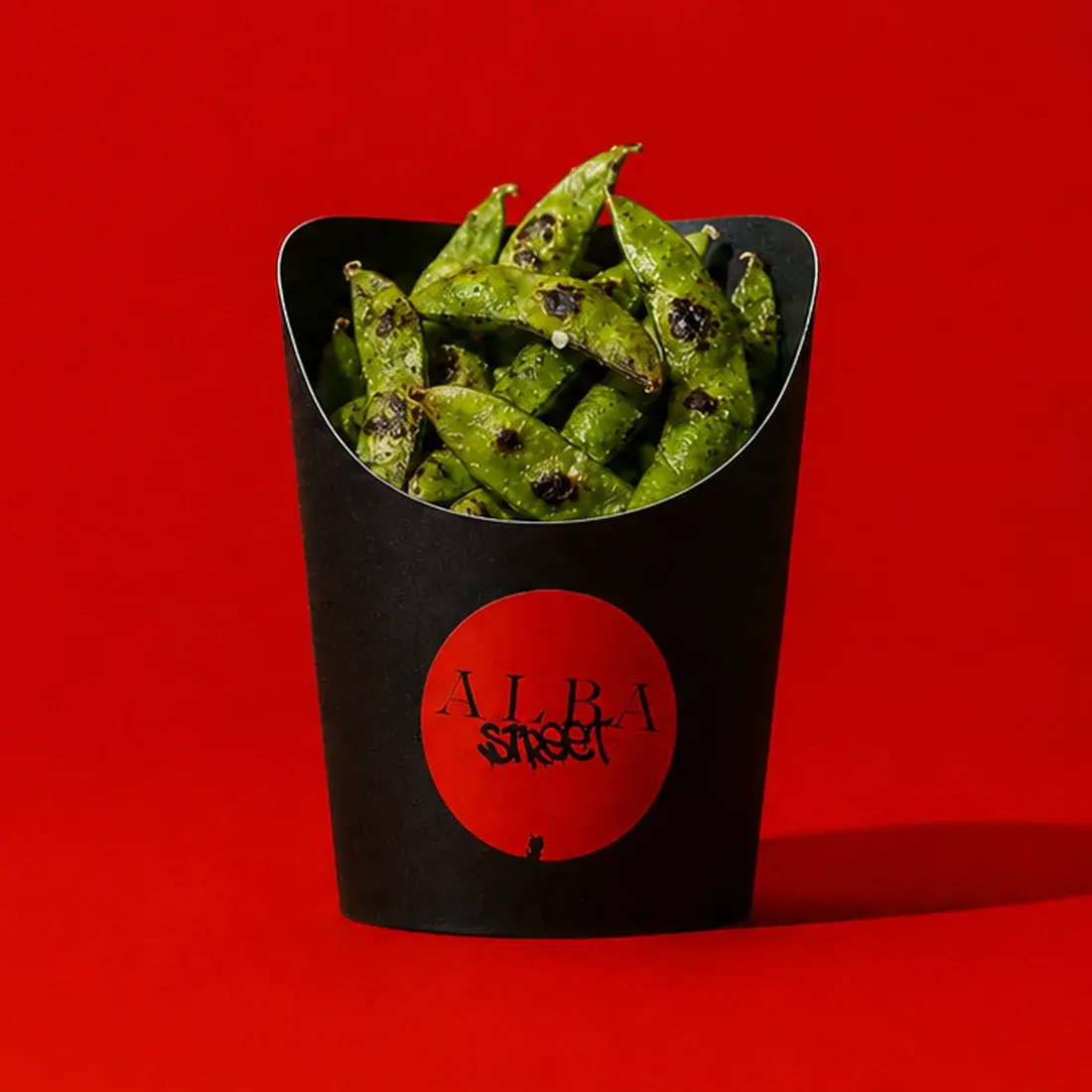 Salted edamame in a black Alba Street carton against a red backdrop at Alba Street, Social Distrikt, Dubai Mall