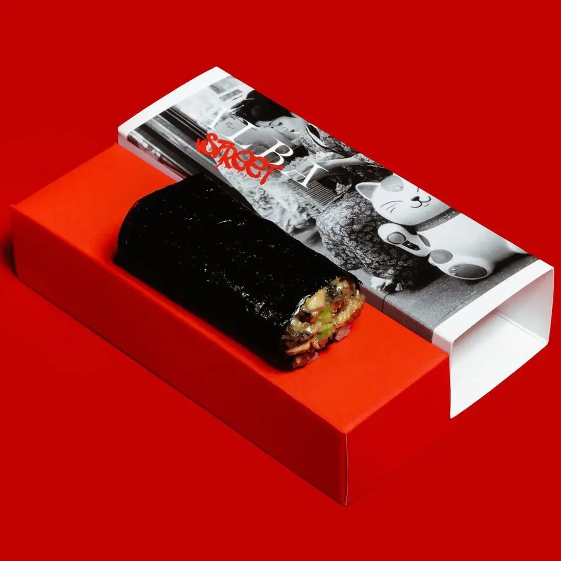 Eel Unagi Handroll in an Alba Street presentation box against a red backdrop at Alba Street, Social Distrikt, Dubai Mall