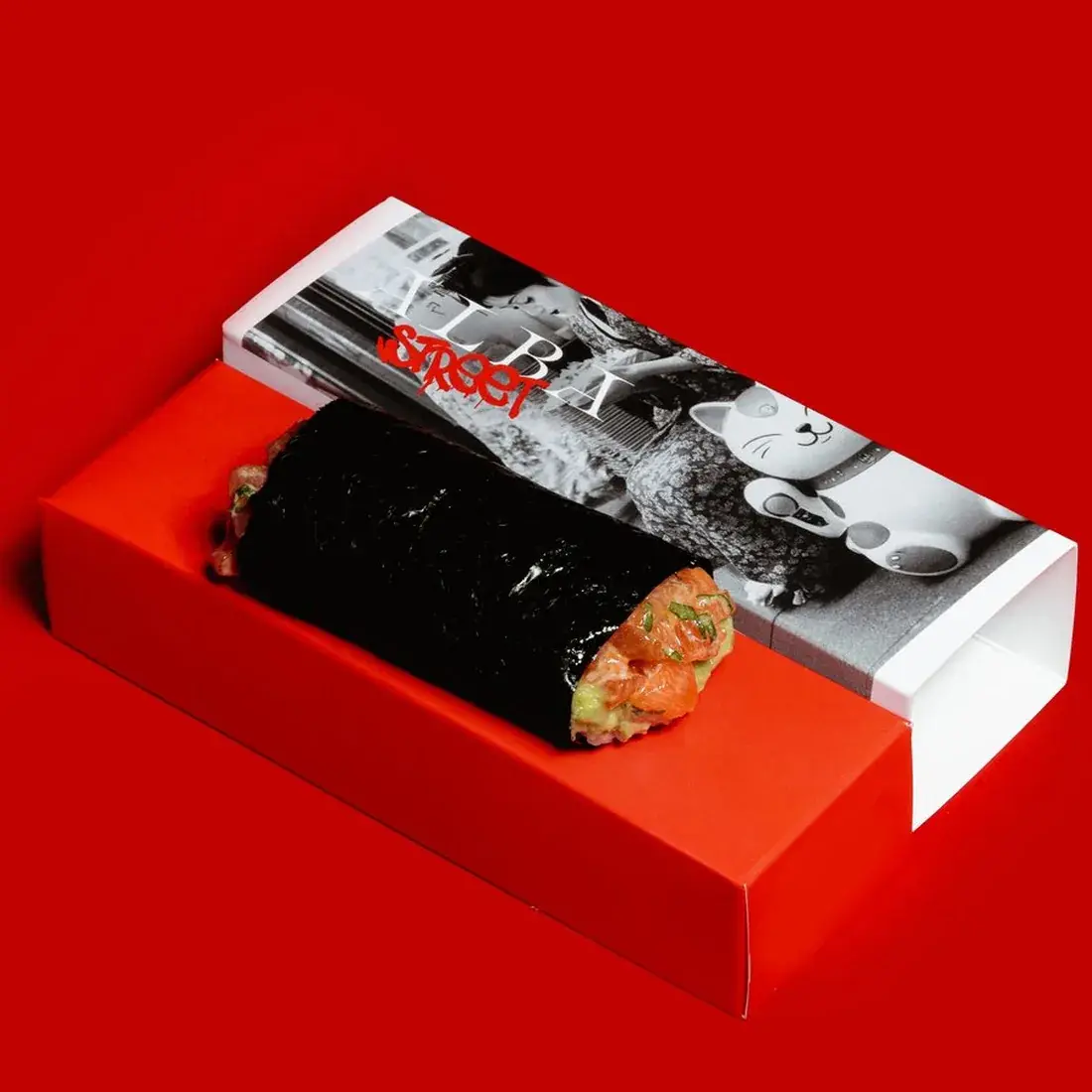 Salmon Handroll in an Alba Street presentation box against a red backdrop at Alba Street, Social Distrikt, Dubai Mall
