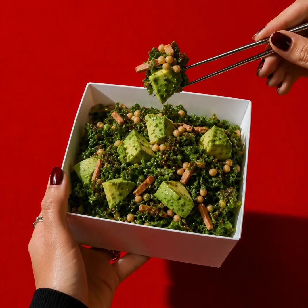 Kale Salad in Alba Street packaging, held against a red backdrop at Social Distrikt, Dubai Mall