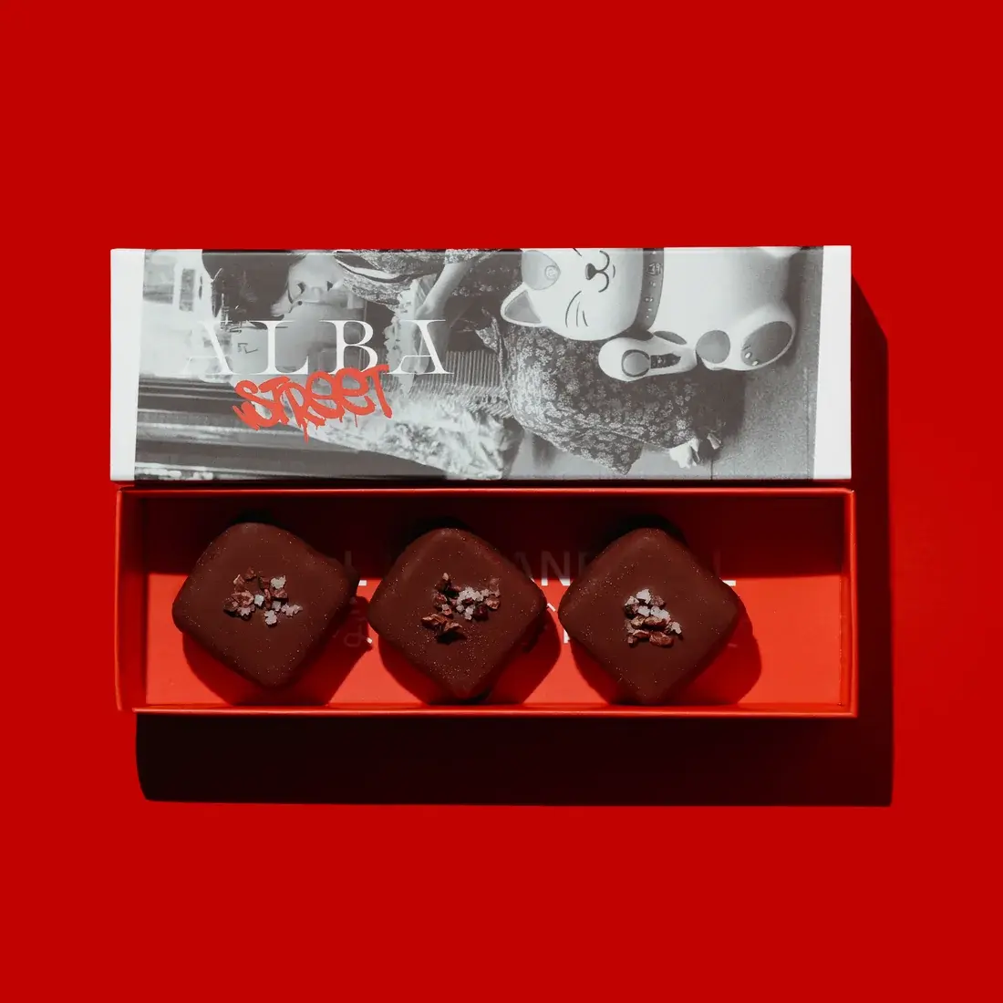 Miso Snickers — three chocolate cubes in an Alba Street presentation box, shot against a red backdrop at Alba Street, Social Distrikt, Dubai Mall