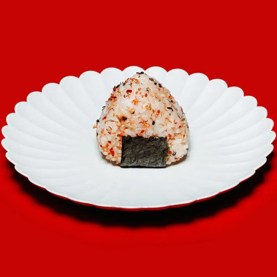 A5 Wagyu Onigiri on a fluted white plate against a red backdrop at Alba Street, Social Distrikt, Dubai Mall