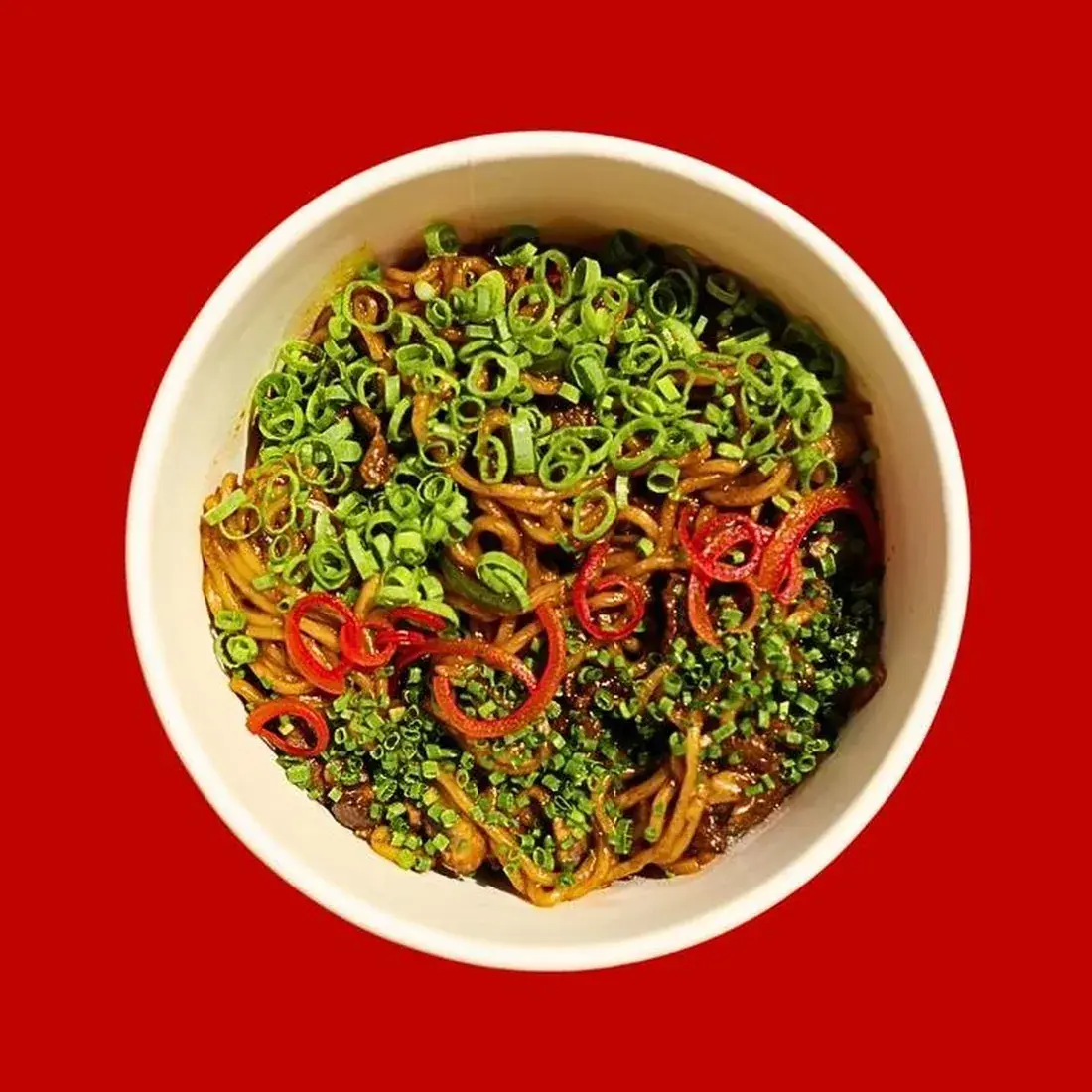 Stir Fried Noodles with Wagyu in a bowl against a red backdrop at Alba Street, Social Distrikt, Dubai Mall